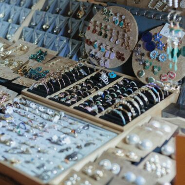 A close-up of a jewelry display showcasing a variety of handcrafted earrings and rings.
