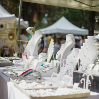 Elegant outdoor jewelry stall showcasing luxury accessories at a market under tents.